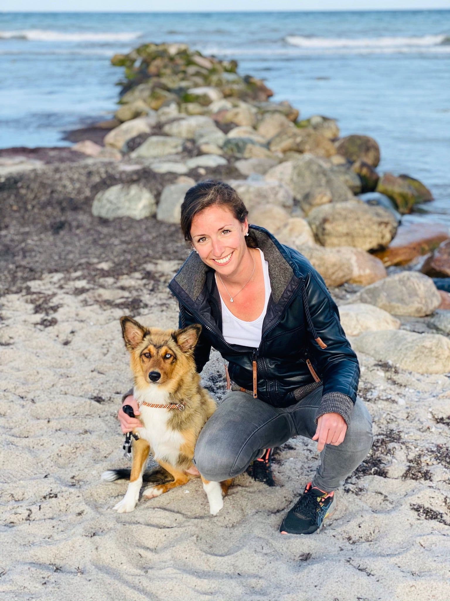 Marion kniet neben Holly am Strand